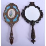 TWO EARLY 20TH CENTURY FRENCH BRASS HAND MIRRORS one with enamelled backing. 28 cm x 12 cm. (2)