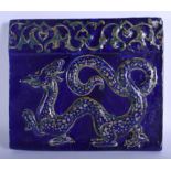 A 19TH CENTURY PERSIAN IRANIAN BLUE GLAZED QAJAR POTTERY TILE depicting a dragon and flowers. 29 cm