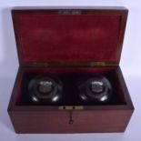 A PAIR OF VICTORIAN SILVER MOUNTED BOWLS within a fitted case. Each 11 cm wide. (3)