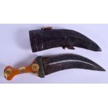 AN ANTIQUE MIDDLE EASTERN AMBER AND GOLD HANDLED JAMBIYA DAGGER. 31 cm long.