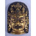 AN 18TH CENTURY CHINESE TIBETAN GILT BRONZE BUDDHISTIC MASK HEAD Qing, decorated with skulls and emb