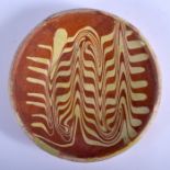 AN 18TH CENTURY DUTCH POTTERY SLIP DECORATED DISH painted with a marbleised motifs. 18 cm diameter.
