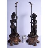 A RARE LARGE PAIR OF 19TH CENTURY LACQUERED WOOD NUBIAN FIGURES modelled standing upon a scrolling a
