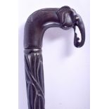 A 19TH CENTURY SRI LANKAN CARVED EBONY ELEPHANT WALKING CANE. 92 cm long.