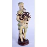 AN 18TH/19TH CENTURY ENGLISH WHIELDON TYPE POTTERY FIGURE OF A PIPER modelled upon a brown glazed ba