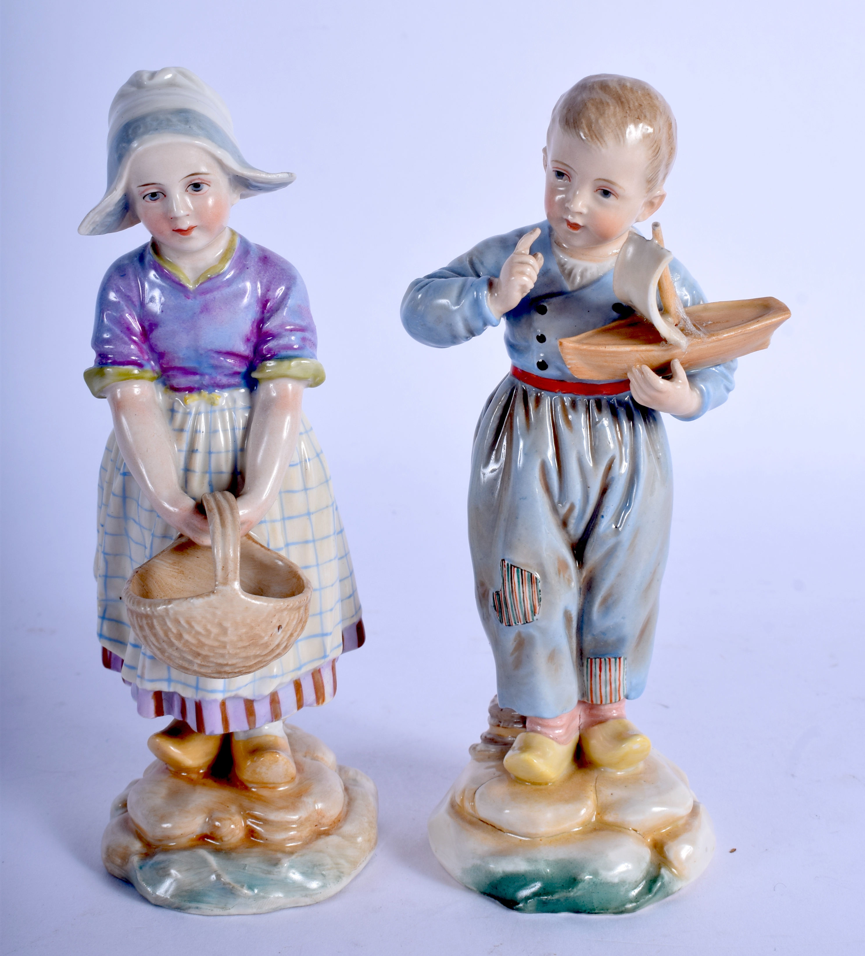 A PAIR OF 19TH CENTURY GERMAN PORCELAIN FIGURES possibly Hoscht, one holding a toy boat. 15 cm high.