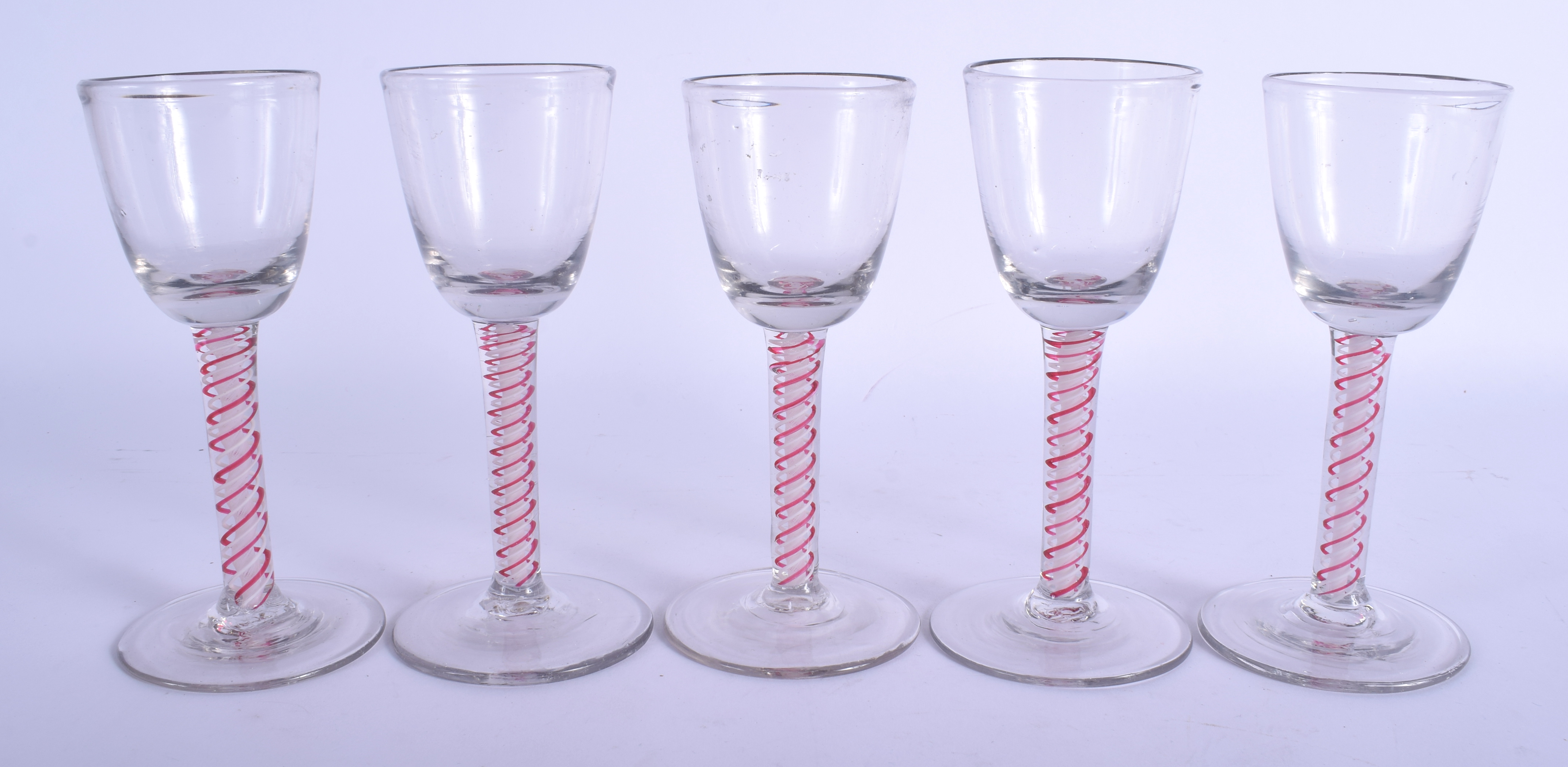 A SET OF FIVE 18TH CENTURY ENGLISH GLASSES C1770 with pink and white spiral twist stems. 16 cm high.