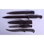 TWO MILITARY DAGGERS together with a silver inlaid knife. Largest 33 cm long. (3)