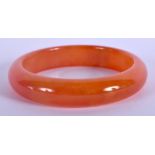 AN EARLY 20TH CENTURY CHINESE CARVED ORANGE JADE AGATE BANGLE Late Qing/Republic. 6.5 cm wide.