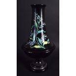 A VICTORIAN ENAMELLED BLACK GLASS VASE decorated with floral sprays. 29 cm high.