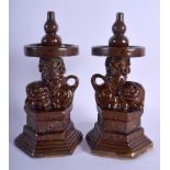 A PAIR OF 19TH CENTURY CHINESE BROWN GLAZED STONEWARE ALTAR STICKS Qing, formed with buddhistic lion