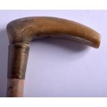 A 19TH CENTURY CONTINENTAL CARVED RHINOCEROS HORN WALKING CANE with bamboo shaft. 99 cm long.