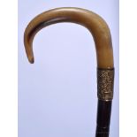 A 19TH CENTURY CONTINENTAL CARVED RHINOCEROS HORN HANDLED WALKING CANE with bamboo shaft. 73 cm long