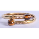 A VICTORIAN 15CT GOLD PEARL AND TIGERS EYE BANGLE. 14 grams. 5.5 cm wide.