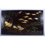 A 19TH CENTURY JAPANESE MEIJI PERIOD LACQUERED WOOD PANEL depicting birds in flight. 58 cm x 35 cm.