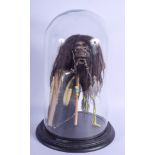 A TRIBAL SHRUNKEN HEAD within a glass dome. 44 cm x 17 cm overall.