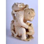 A 19TH CENTURY JAPANESE MEIJI PERIOD CARVED IVORY OKIMONO modelled as a monkey holding frogs. 7 cm x