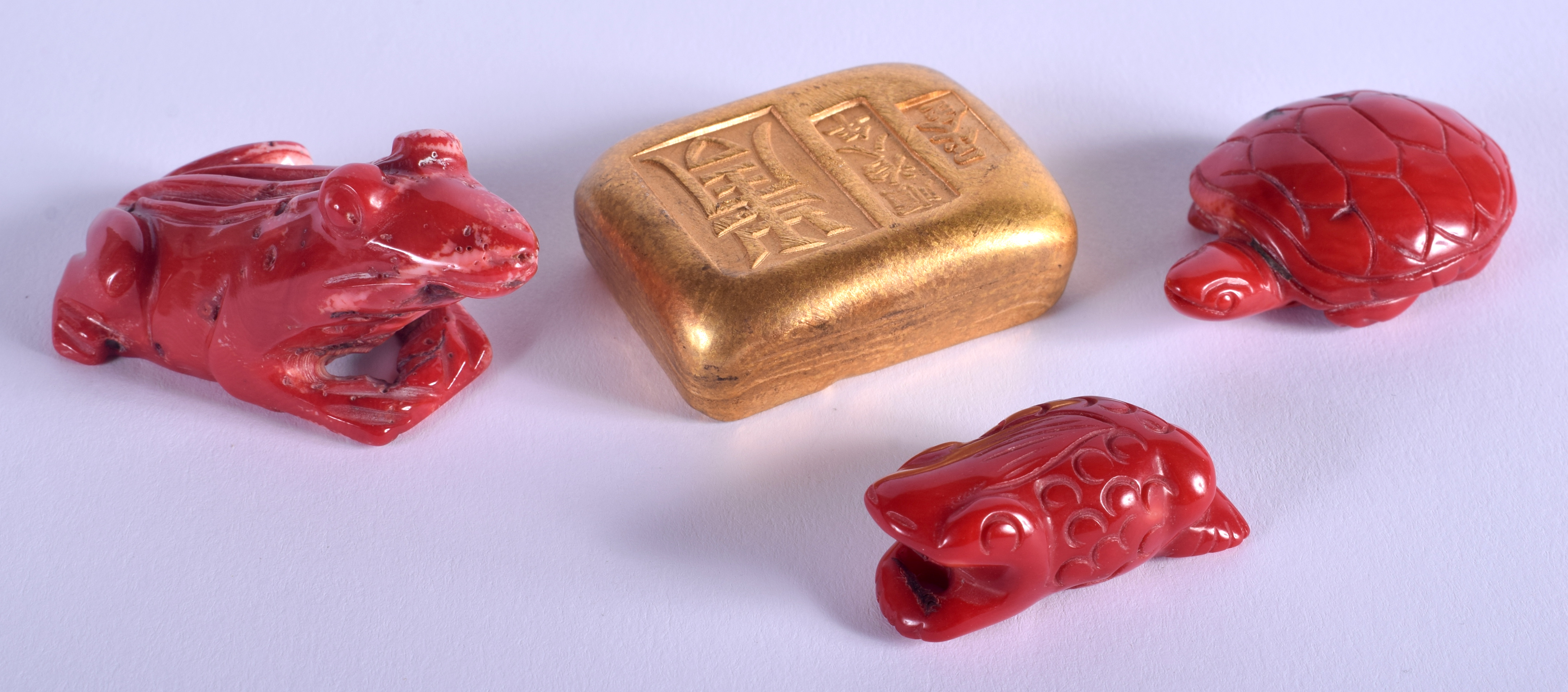 A CONTEMPORARY CHINESE YELLOW METAL INGOT together with three vintage coral figures. (4)