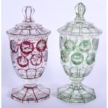 A PAIR OF BOHEMIAN GLASS JARS AND COVERS decorated with animals and landscapes. 17 cm high.