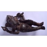 A 19TH CENTURY INDIAN BRONZE FIGURE OF A RECLINING GANESHA modelled in foliate robes. 15 cm x 10 cm.