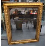 A MID 19TH CENTURY EUROPEAN RIPPLE MOULDED GILT WOOD MIRROR. 97 cm x 77 cm.