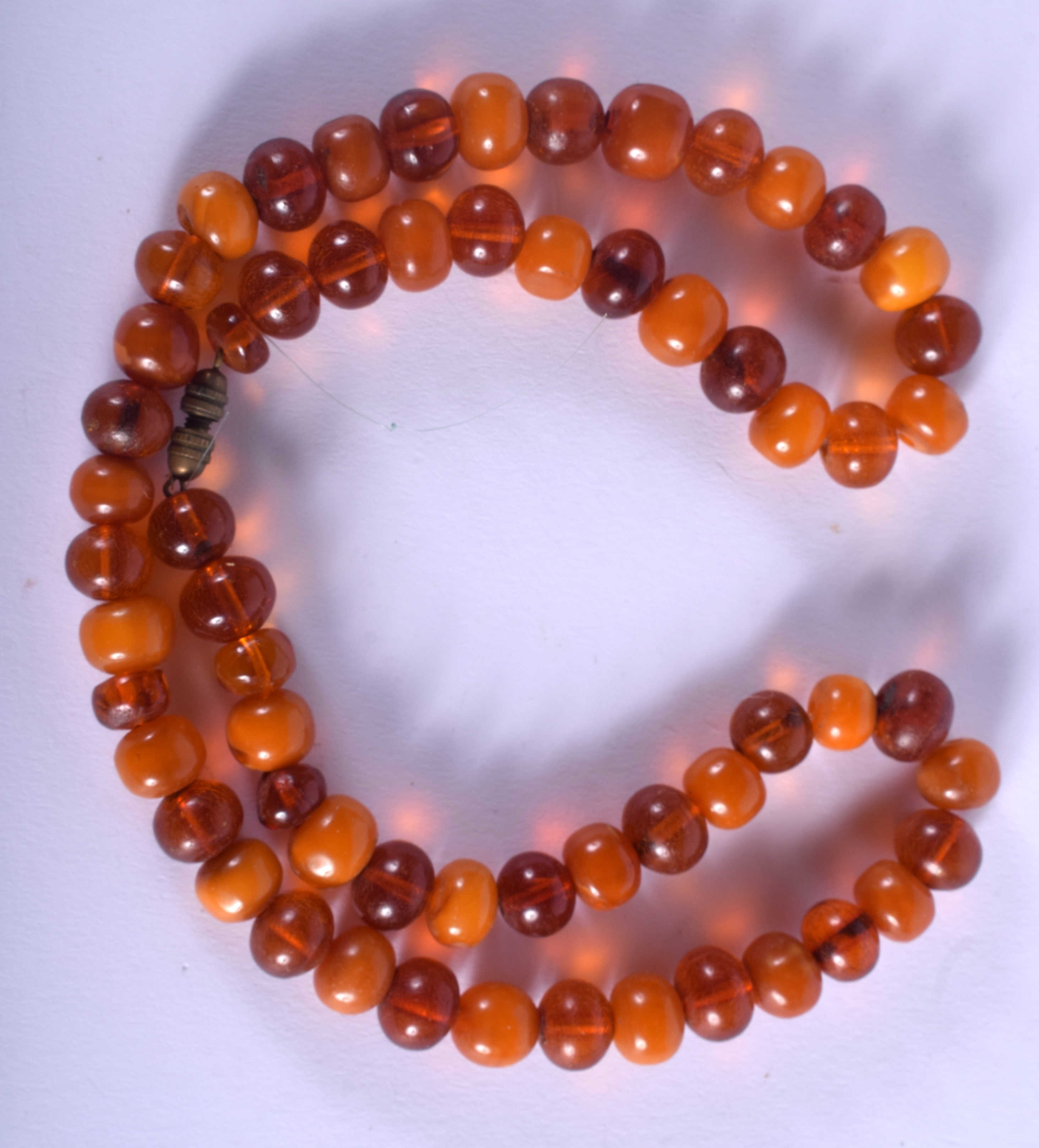 A 1930S ORANGE AND BUTTERSCOTCH AMBER NECKLACE of uni-form. 35 grams. 48 cm long, each bead 0.5 cm w