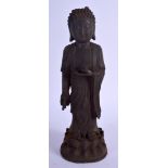 A CHINESE MING DYNASTY IRON FIGURE OF A STANDING BUDDHA modelled upon a lotus capped base. 29 cm hig