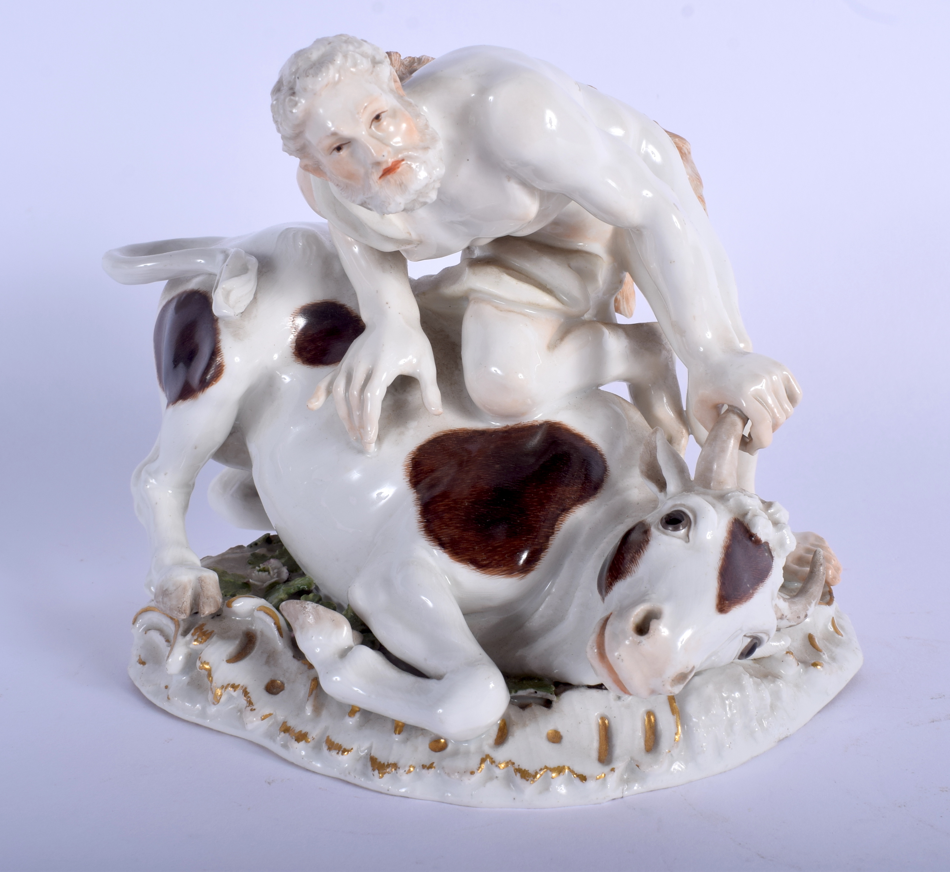 A LOVELY 19TH CENTURY MEISSEN PORCELAIN FIGURE OF A MUSCULAR MALE modelled taming a bull upon a natu