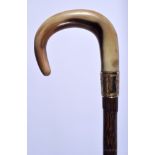 A 19TH CENTURY CONTINENTAL CARVED BUFFALO HORN HANDLED WALKING CANE with bamboo shaft. 86 cm long.