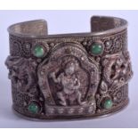 AN ANTIQUE TIBETAN SILVER AND JADEITE BUDDHISTIC BANGLE. 106 grams.