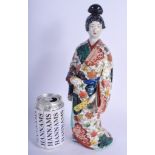 A 19TH CENTURY JAPANESE MEIJI PERIOD KAKIEMON IMARI FIGURE OF A FEMALE modelled holding a fan. 32 cm