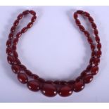 A 1930S CHERRY AMBER CATALIN TYPE NECKLACE of graduated form. 62 grams. 68 cm long, largest bead 3 c