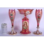 A 19TH CENTURY BOHEMIAN CRANBERRY GLASS GARNITURE enamelled with a portrait of a female, the vases o
