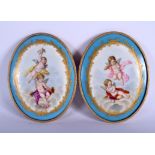 A PAIR OF 19TH CENTURY FRENCH SEVRES PORCELAIN PLAQUES painted with putti within landscapes. 13 cm x