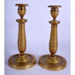 A PAIR OF 19TH CENTURY FRENCH EMPIRE GILT METAL CANDLESTICKS decorated with a flower banding. 23 cm