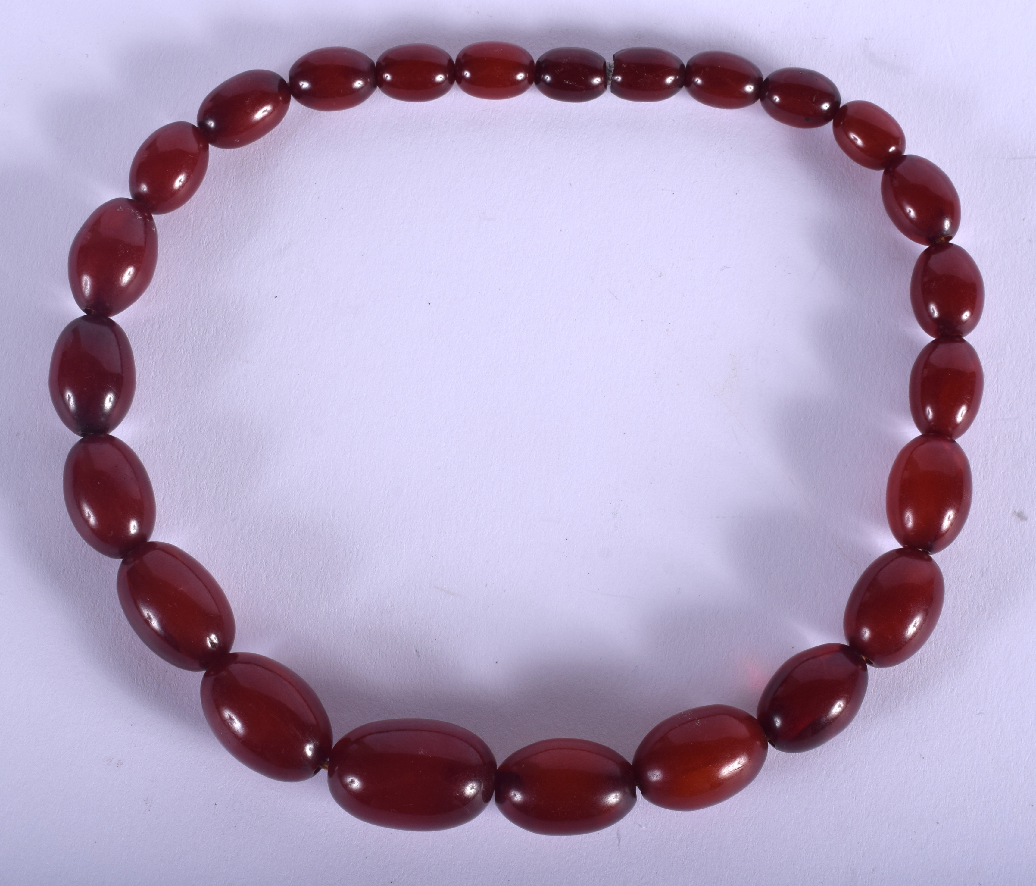 AN EARLY 20TH CENTURY CARVED RED AMBER BAKELITE TYPE NECKLACE of graduated form. 47 grams. 40 cm lon