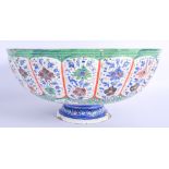 A LARGE MIDDLE EASTERN PERSIAN ENAMELLED TIN BOWL painted with flowers and a river scene. 34 cm x 15