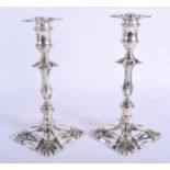 A PAIR OF ANTIQUE SILVER PLATED CANDLESTICKS upon acanthus capped bases. 24 cm high.