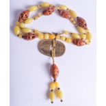 AN EARLY 20TH CENTURY SOUTH EAST ASIAN NUT AND GLASS NECKLACE. 40 cm long.