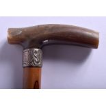A 19TH CENTURY CONTINENTAL CARVED RHINOCEROS HORN HANDLED WALKING CANE with bamboo shaft. 73 cm long