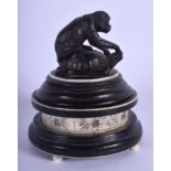 A 19TH CENTURY CONTINENTAL CARVED WOOD AND IVORY BOX AND COVER surmounted with an ape. 12 cm x 6 cm.