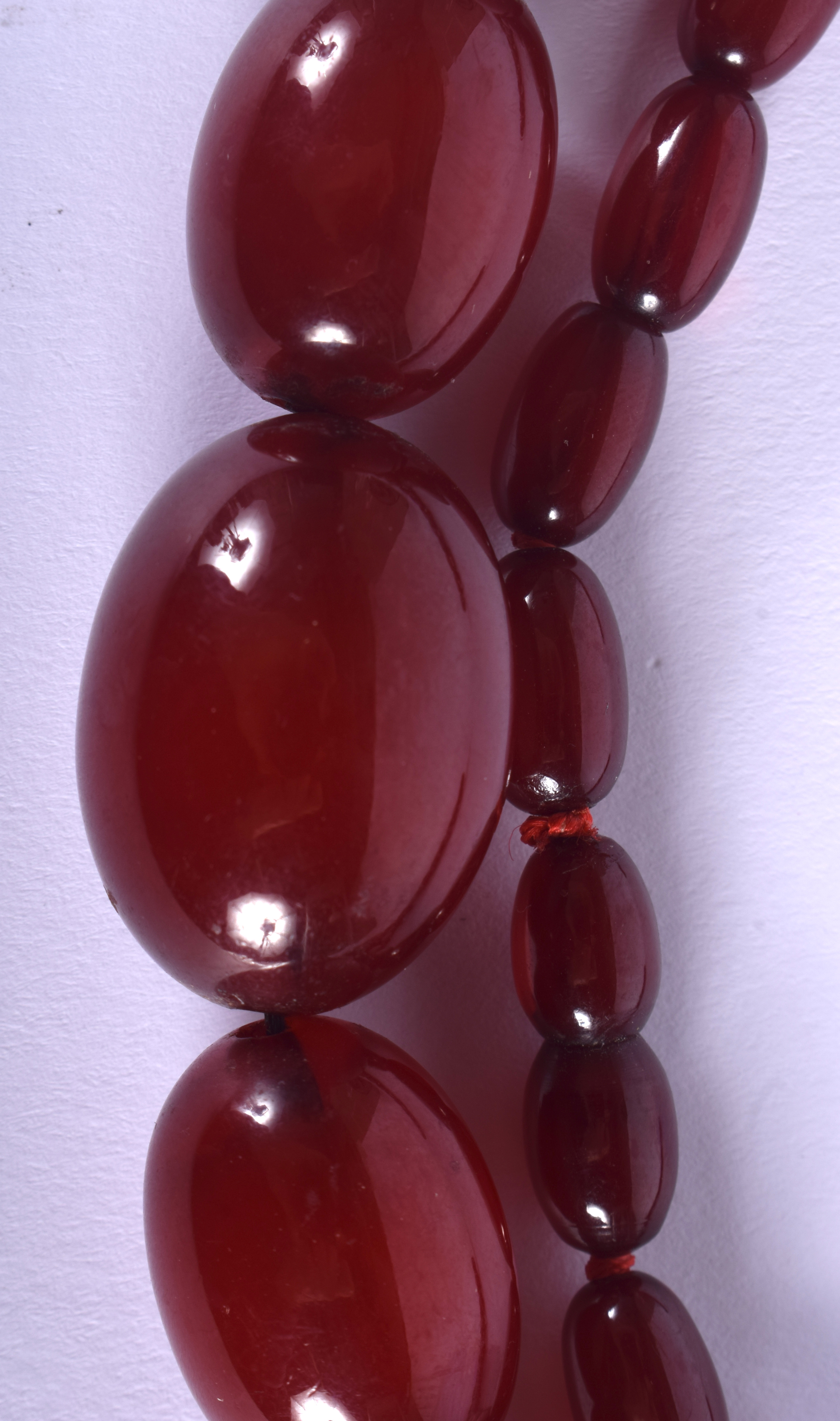 A 1930S CHERRY AMBER CATALIN TYPE NECKLACE of graduated form. 62 grams. 68 cm long, largest bead 3 c - Image 2 of 4