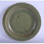 A VERY LARGE CHINESE CELADON SCALLOPED CHARGER probably Late Qing, decorated with a central emblem.