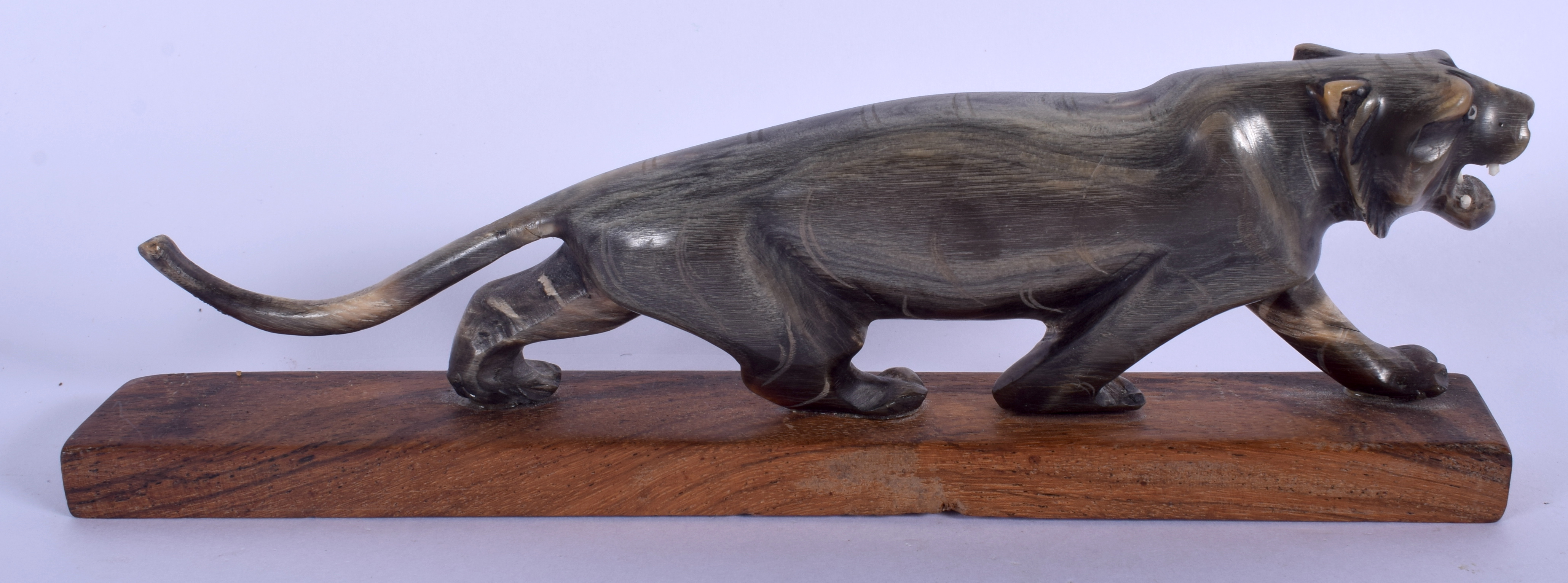 A 19TH CENTURY MIDDLE EASTERN CARVED RHINOCEROS HORN TIGER upon a wooden plinth. Figure 20 cm wide. - Image 2 of 2