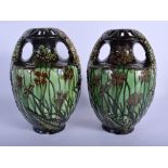 A PAIR OF ART NOUVEAU AUSTRIAN TWIN HANDLED MAJOLICA TYPE VASES painted with flowers. 24 cm high.