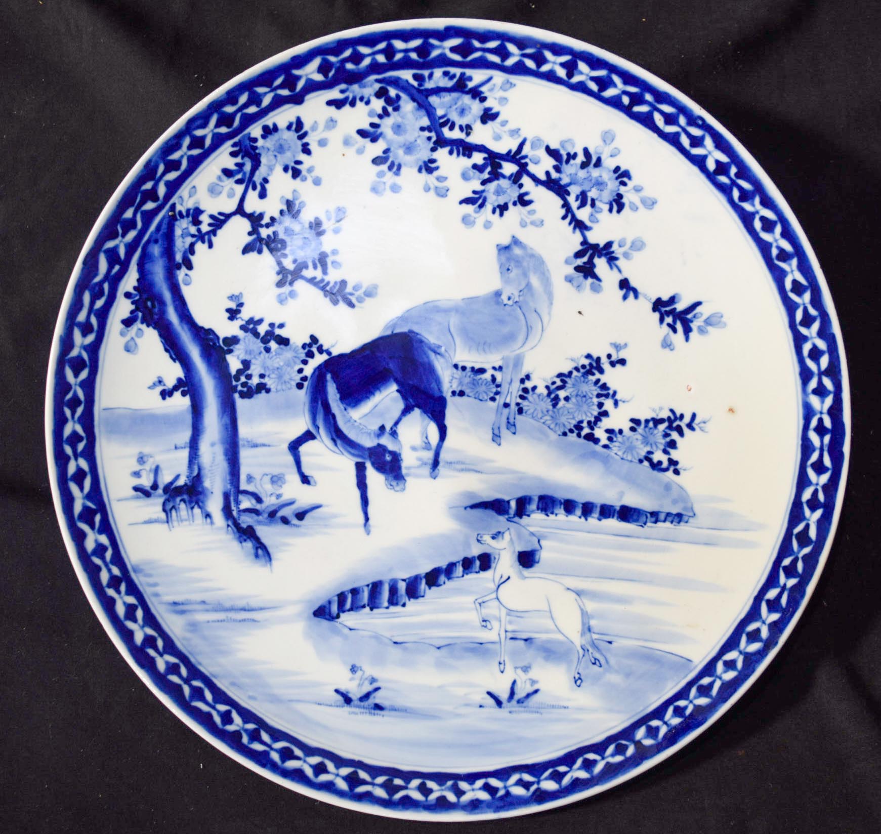 A large Blue and white oriental charger decorated with horses 47cm