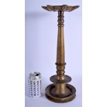 AN EARLY ISLAMIC MIDDLE EASTERN BRONZE CANDLESTICK upon a circular base. 43 cm high.