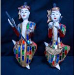 Two painted wooden Thai figures decorated with coloured glass