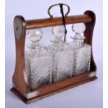 AN ANTIQUE OAK CASED DECANTER SET. 32 cm wide