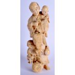 A 19TH CENTURY JAPANESE MEIJI PERIOD CARVED IVORY OKIMONO modelled as a male and two children holdi